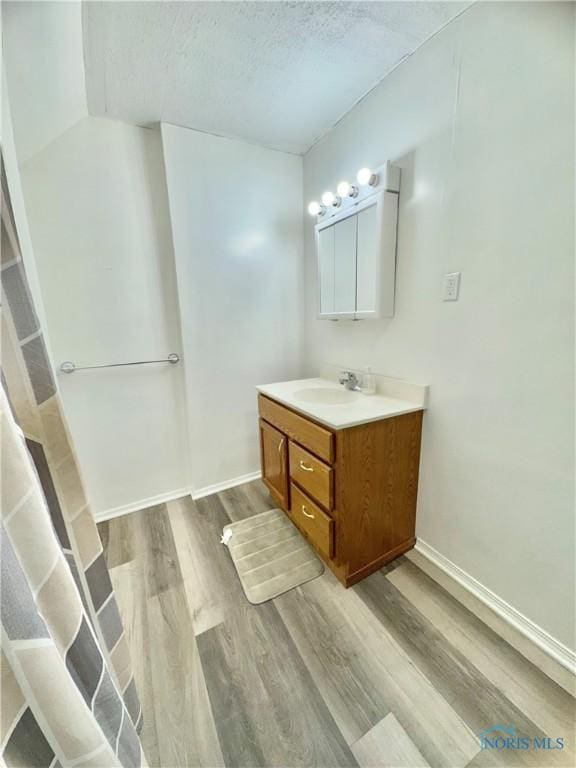 bathroom with vanity, wood-type flooring, and a textured ceiling