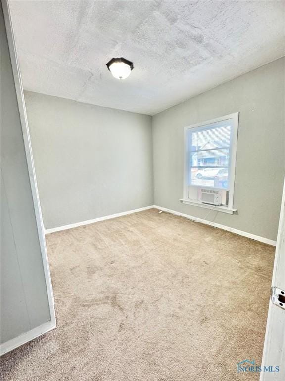 carpeted spare room with cooling unit and a textured ceiling