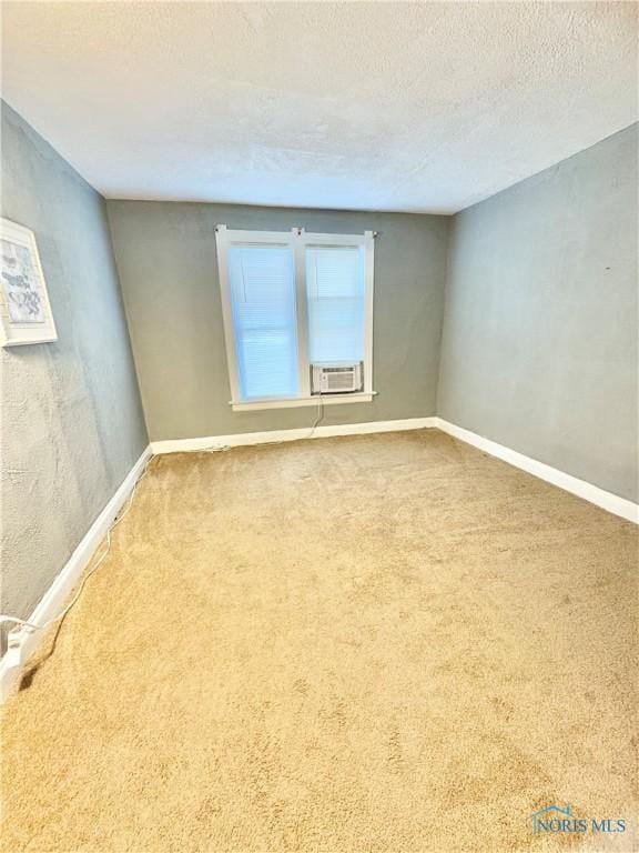 carpeted spare room with cooling unit and a textured ceiling