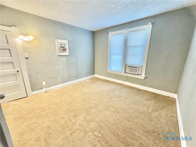 empty room with carpet flooring, a textured ceiling, and cooling unit