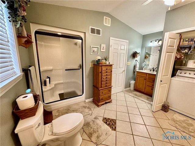 bathroom with vanity, vaulted ceiling, tile patterned flooring, a shower with shower door, and washer / clothes dryer