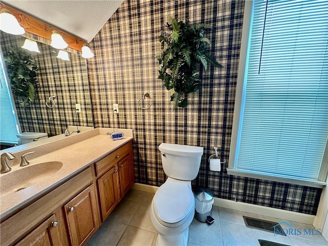 bathroom featuring tile patterned flooring, a textured ceiling, vaulted ceiling, toilet, and vanity