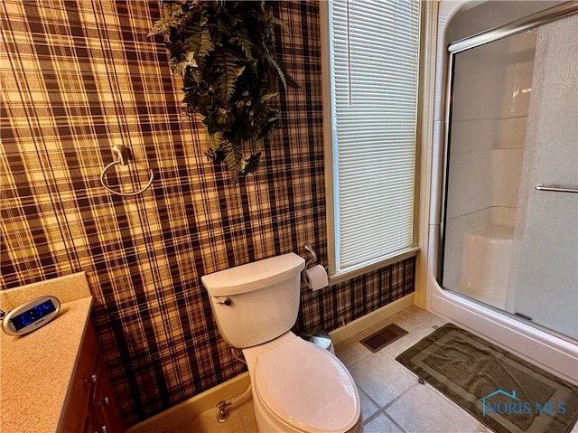 bathroom featuring toilet, tile patterned flooring, vanity, and walk in shower