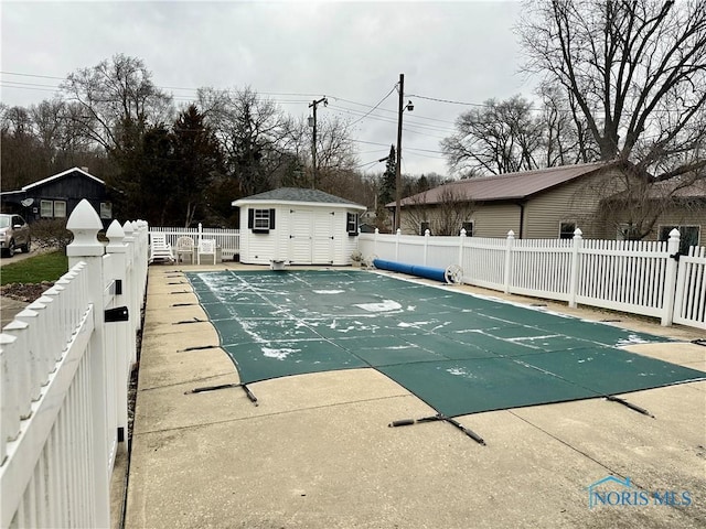 view of swimming pool featuring a patio and a storage unit