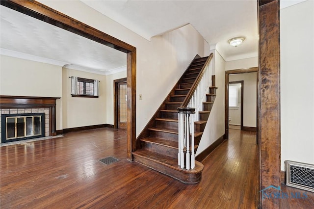 staircase featuring a wealth of natural light, crown molding, and hardwood / wood-style floors