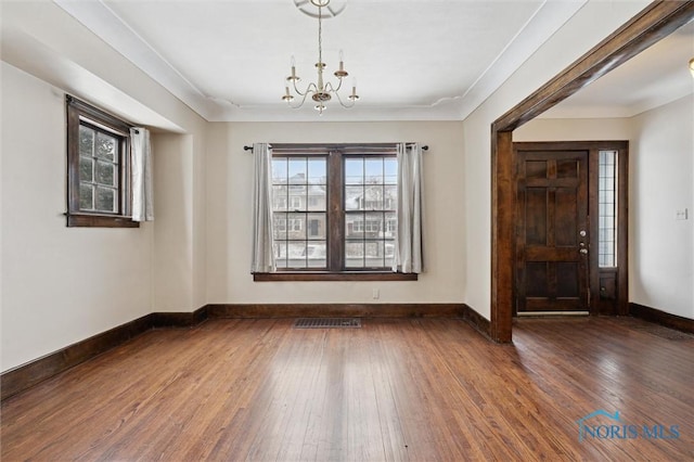 interior space with a chandelier, crown molding, and dark hardwood / wood-style floors