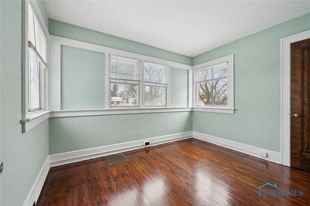 empty room with plenty of natural light and wood-type flooring