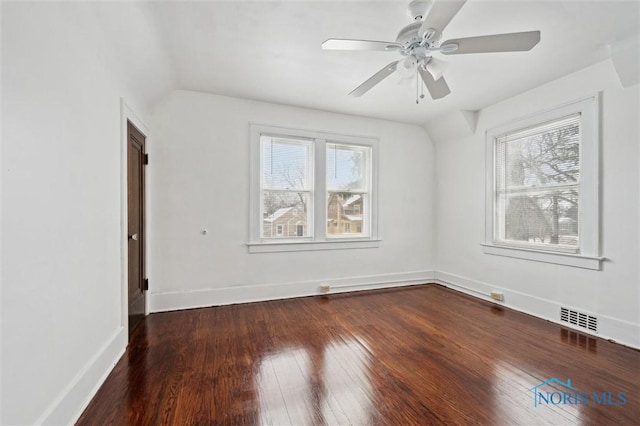 empty room with ceiling fan, dark hardwood / wood-style flooring, and a healthy amount of sunlight