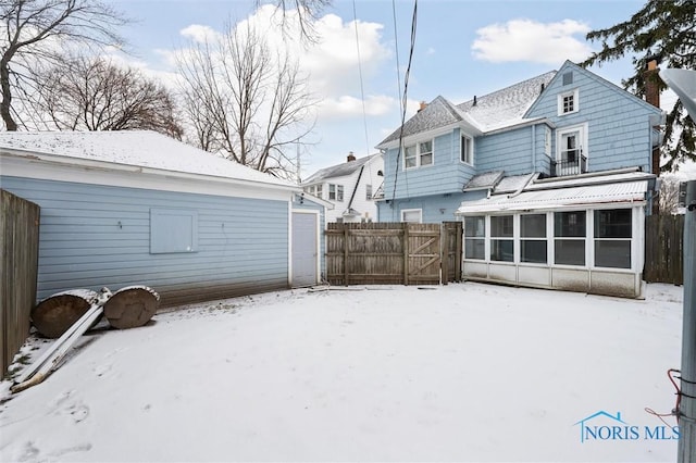 snow covered property featuring a sunroom