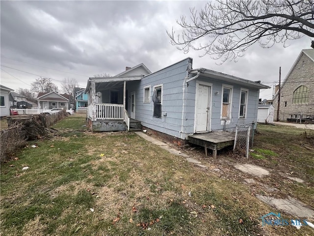 exterior space featuring covered porch and a yard