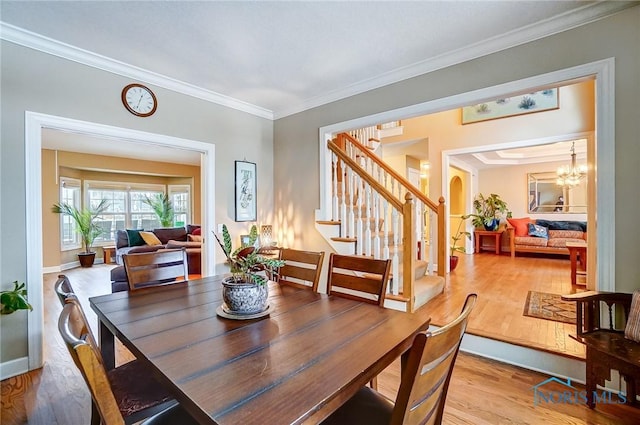 dining room featuring an inviting chandelier, ornamental molding, and light wood-type flooring