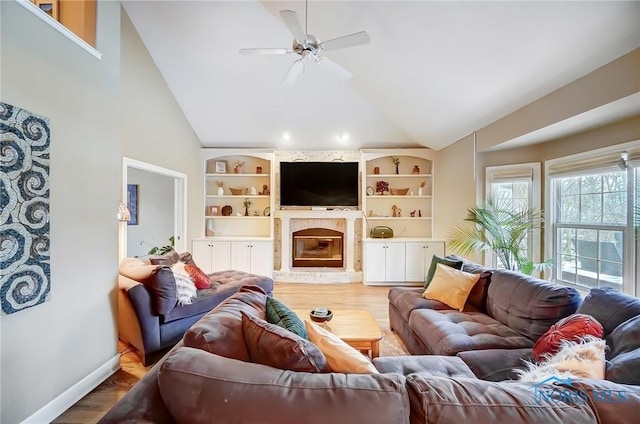 living room featuring hardwood / wood-style flooring, a brick fireplace, ceiling fan, and built in shelves