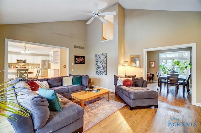 living room featuring hardwood / wood-style flooring, high vaulted ceiling, and ceiling fan