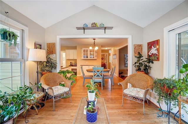 interior space with vaulted ceiling, a notable chandelier, and light hardwood / wood-style flooring