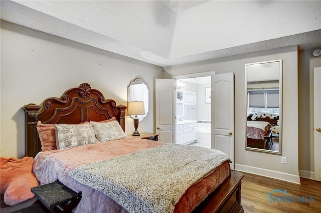 bedroom featuring wood-type flooring and ensuite bathroom