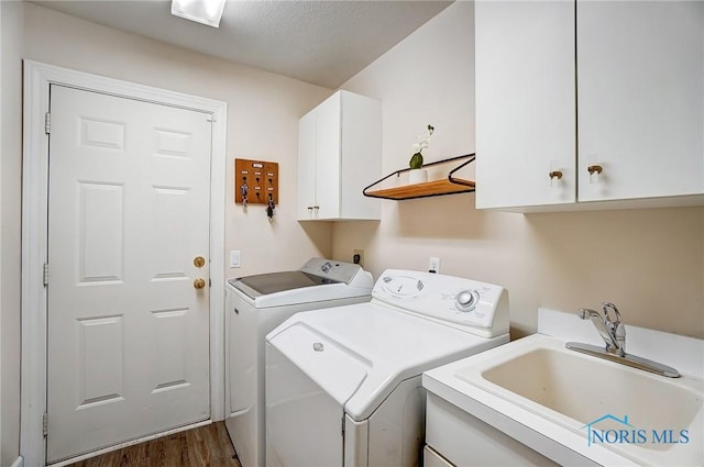 laundry room with cabinets, dark hardwood / wood-style floors, sink, and washing machine and clothes dryer