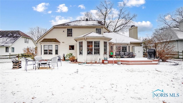 view of snow covered back of property