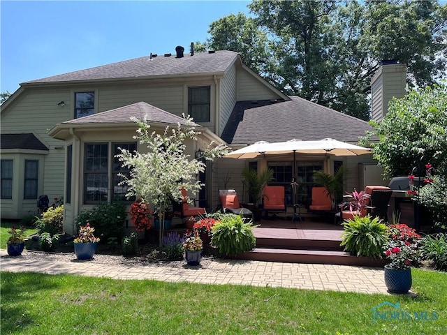 rear view of property featuring a yard and a deck