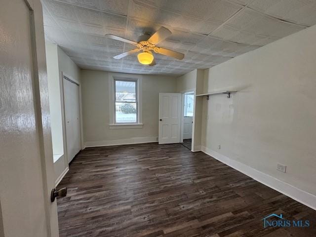 unfurnished bedroom featuring ceiling fan and dark wood-type flooring