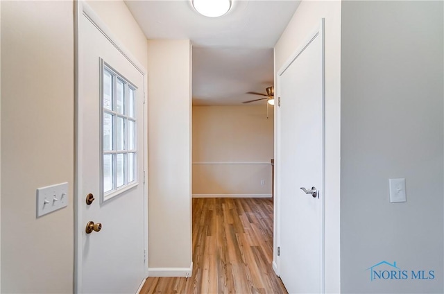 doorway with ceiling fan and light hardwood / wood-style floors