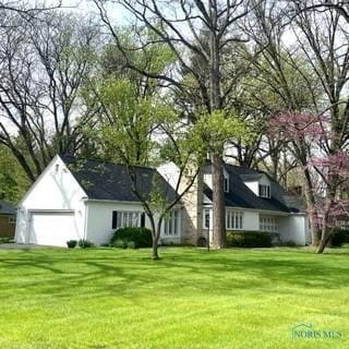 view of front of property featuring a garage and a front lawn