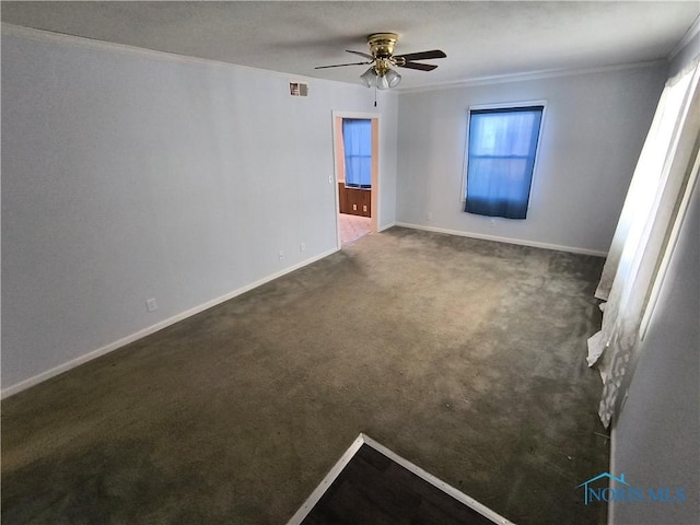 carpeted spare room with ceiling fan and crown molding