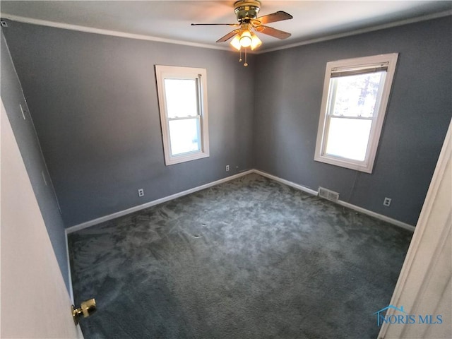 carpeted empty room featuring ceiling fan, plenty of natural light, and ornamental molding