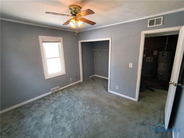 unfurnished bedroom with gas water heater, ceiling fan, crown molding, carpet floors, and a closet