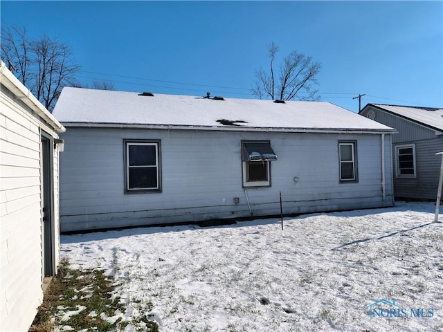 view of snow covered back of property