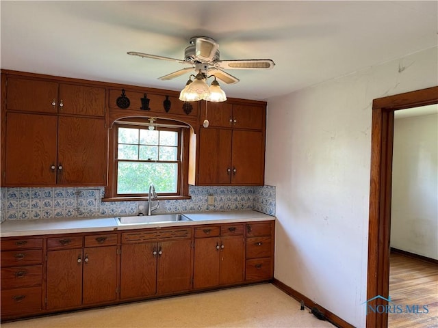 kitchen featuring backsplash, ceiling fan, and sink