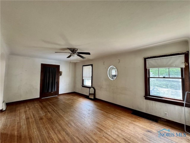 empty room with ceiling fan and hardwood / wood-style floors