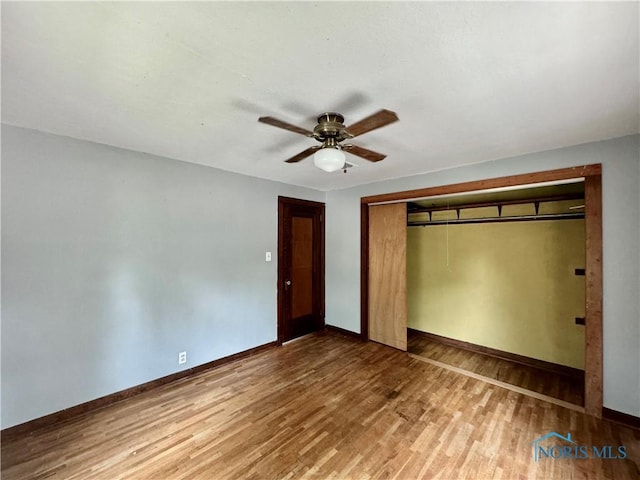 unfurnished bedroom with hardwood / wood-style flooring, ceiling fan, and a closet