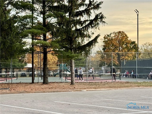 view of home's community featuring tennis court