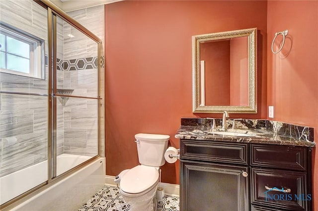 full bathroom with combined bath / shower with glass door, vanity, tile patterned floors, and toilet