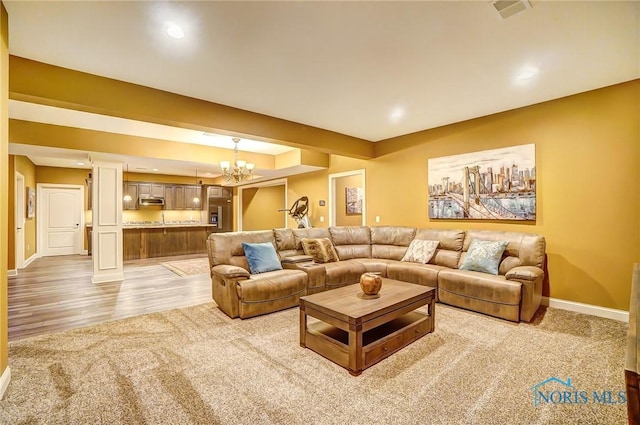 carpeted living room with a notable chandelier