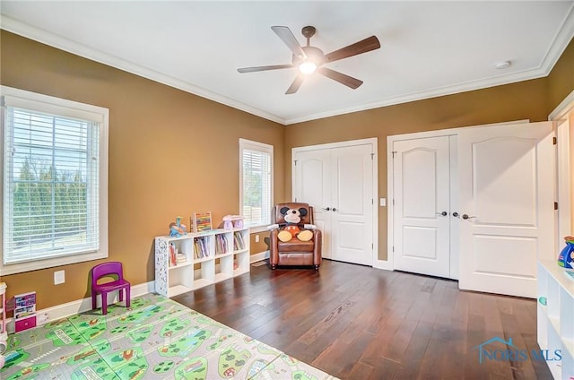 playroom with dark hardwood / wood-style floors, ceiling fan, and ornamental molding