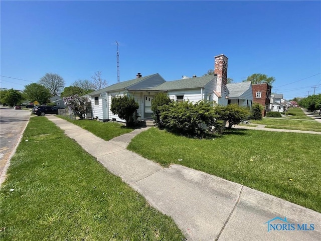 bungalow-style home with a front lawn