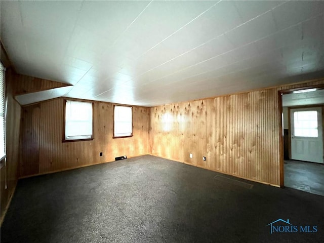 bonus room featuring wood walls