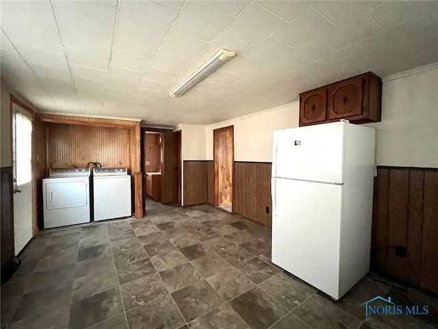 interior space featuring separate washer and dryer, white fridge, and wood walls