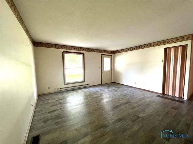 empty room featuring dark hardwood / wood-style flooring and a baseboard radiator