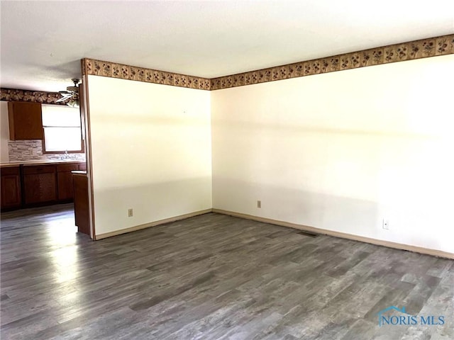 spare room featuring dark wood-type flooring and sink