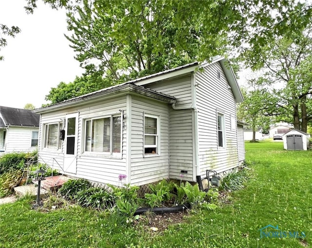 view of home's exterior with a yard and a shed