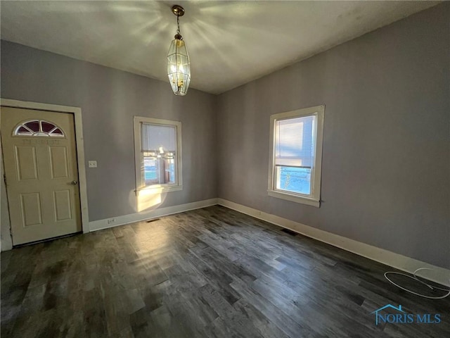 entryway with dark hardwood / wood-style floors and a chandelier