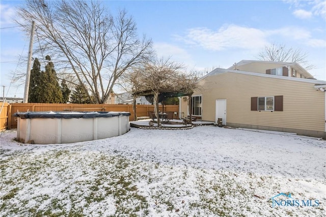 snow covered property featuring a covered pool