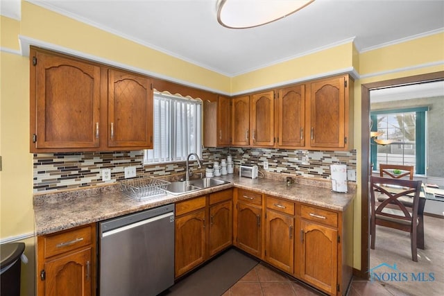 kitchen with stainless steel dishwasher, sink, dark tile patterned flooring, and tasteful backsplash