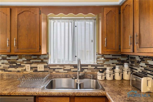 kitchen with dishwasher, sink, and tasteful backsplash