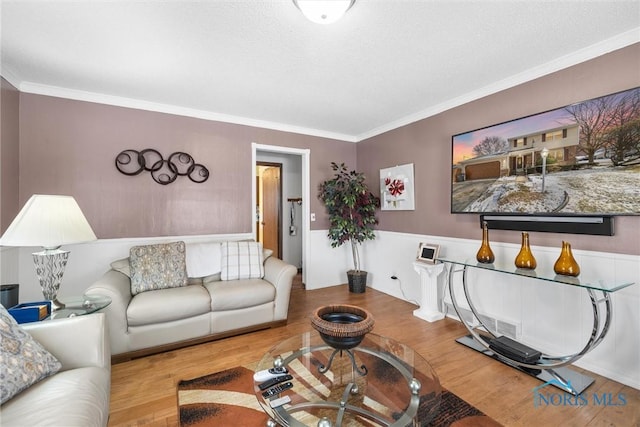 living room featuring wood-type flooring and ornamental molding