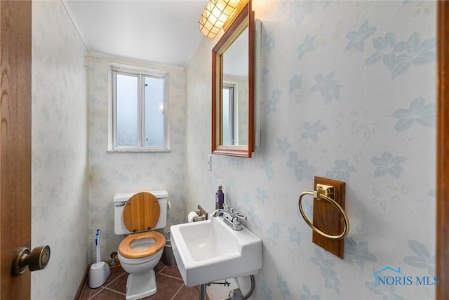 bathroom featuring tile patterned flooring, toilet, ornamental molding, and sink