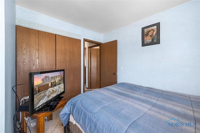 bedroom featuring a textured ceiling and a closet