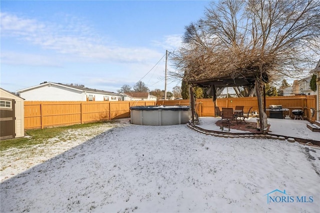 yard layered in snow with a covered pool